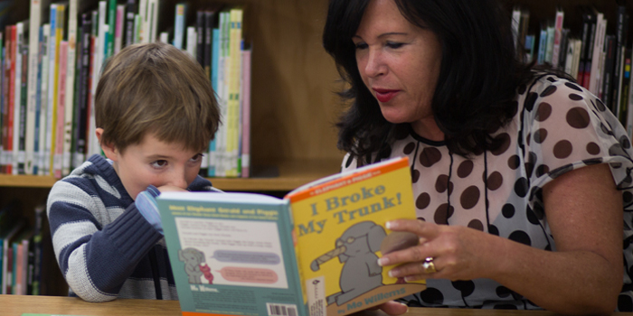 Terri Browning, Umpqua Bank Regional Director and SMART board member, reads to a child.