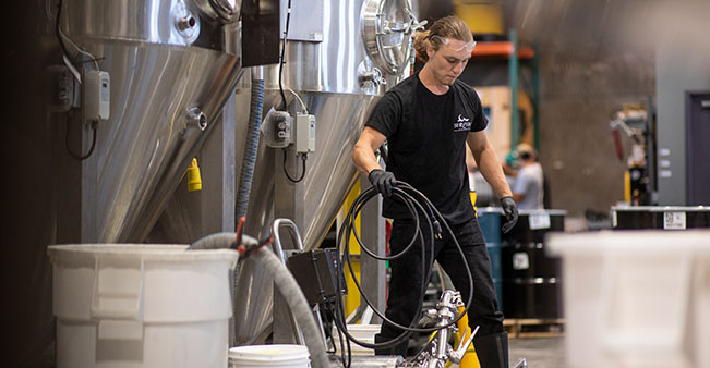 Person moves equipment at cider distillery