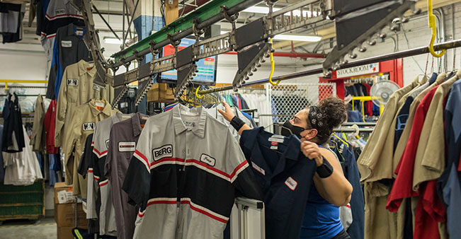 Person loads clothes onto industrial cleaner rack