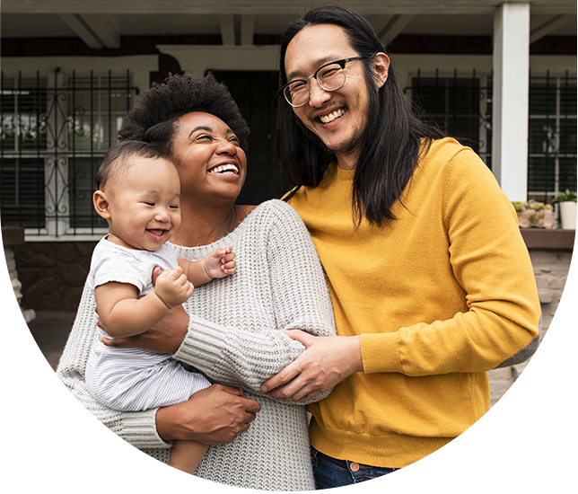 Smiling family outside house