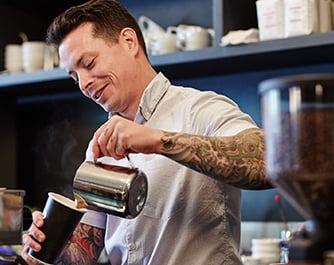 Tattooed barista making coffee