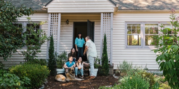 Smiling family outside new home