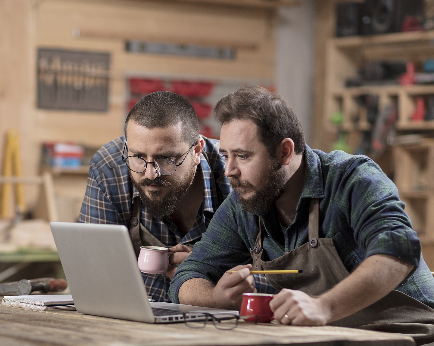 Two men look at laptop