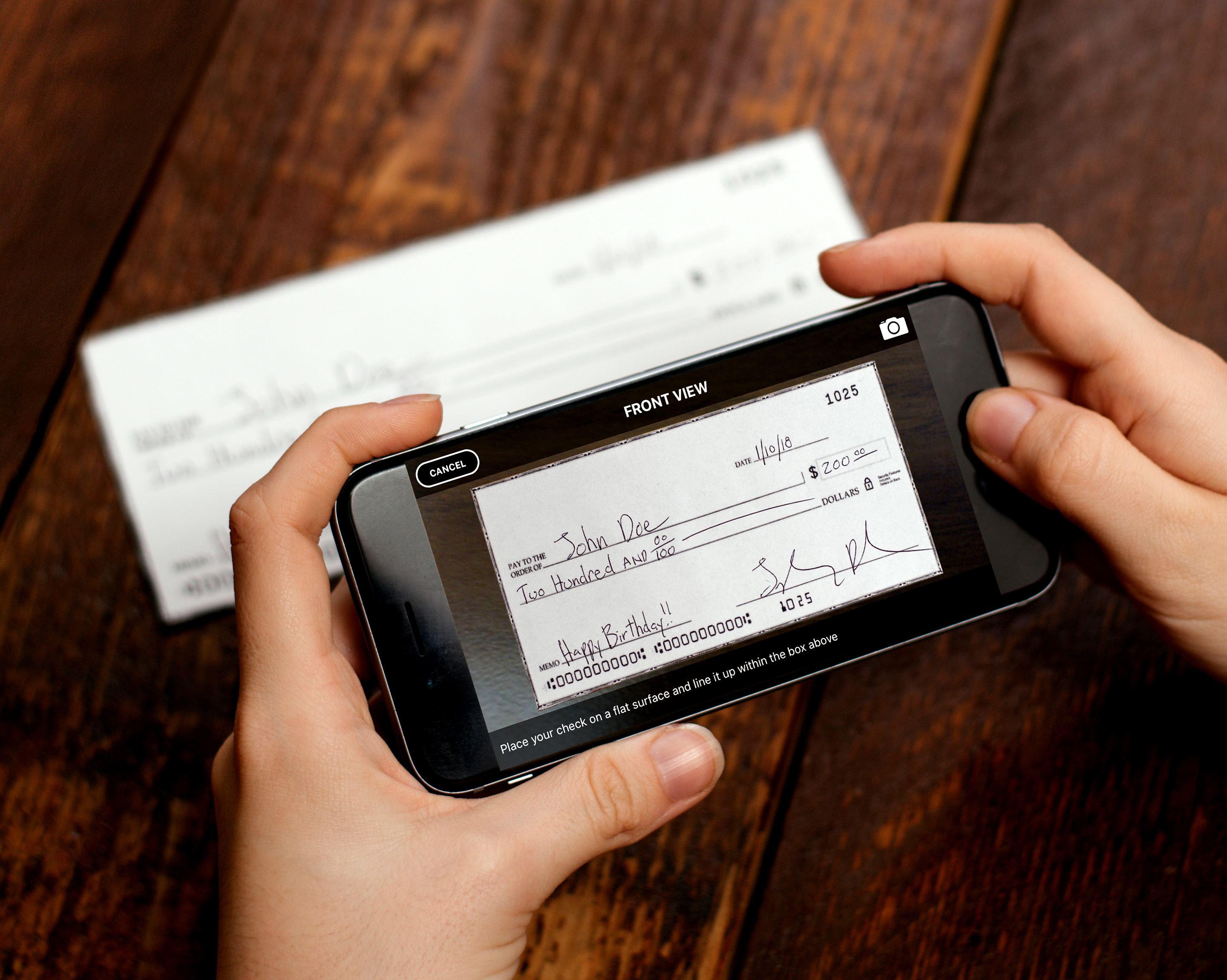 Person takes photo of check using mobile phone