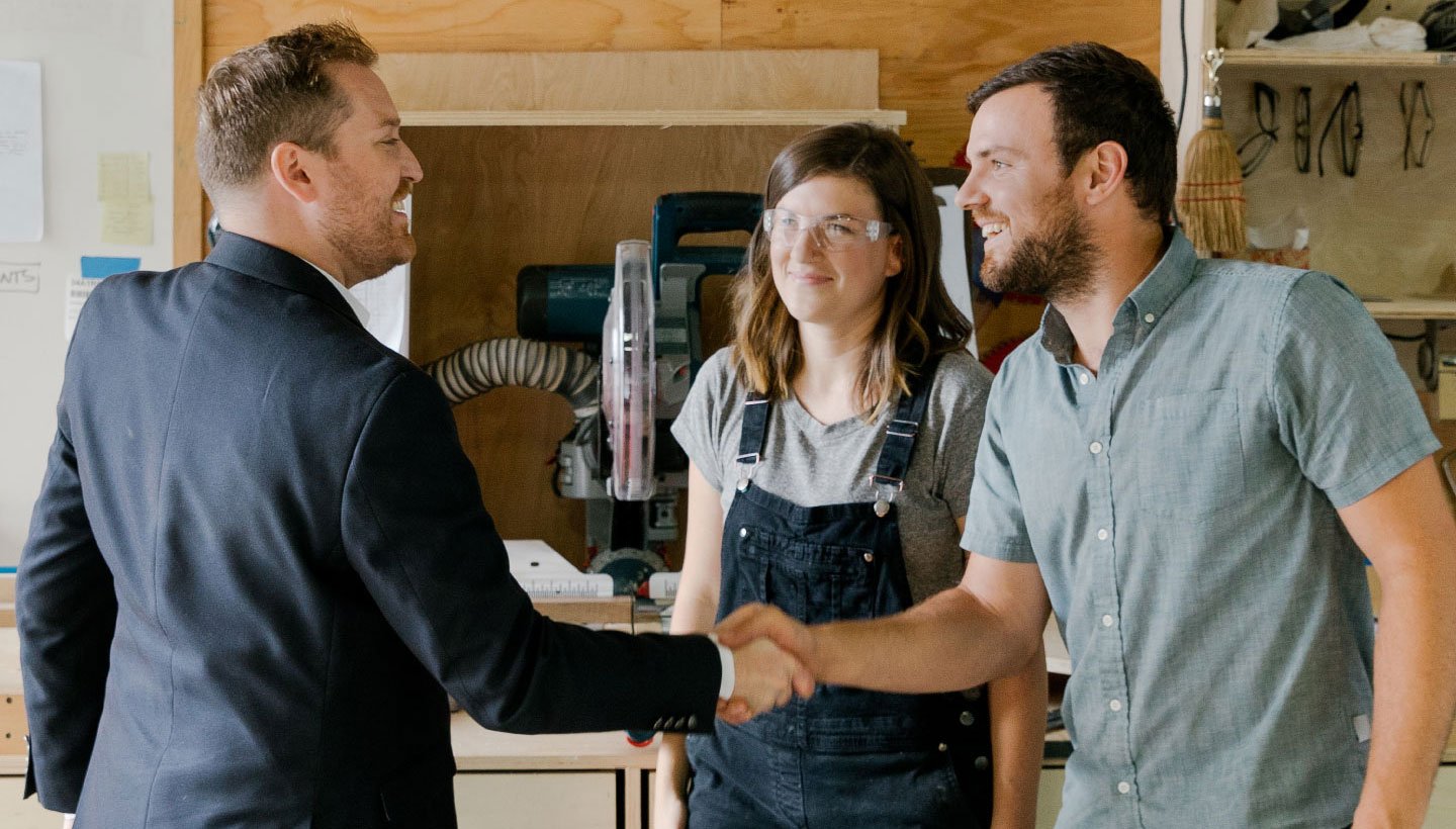 Business owners shake hands with banker
