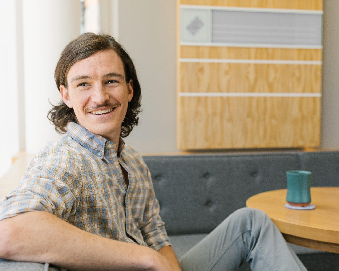 Person smiles next to cup of coffee